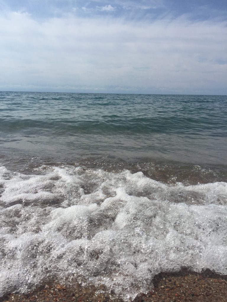 イシククル湖の波打ち際の画像