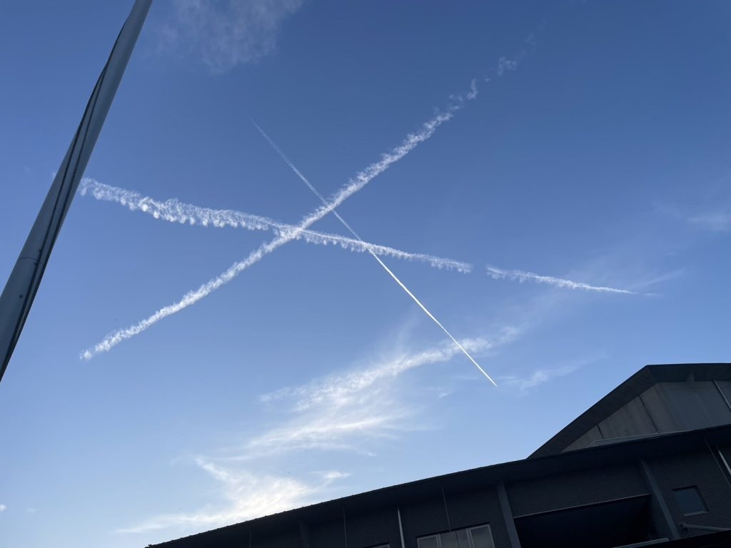 飛行機雲が3重に交差する様子の写真です。